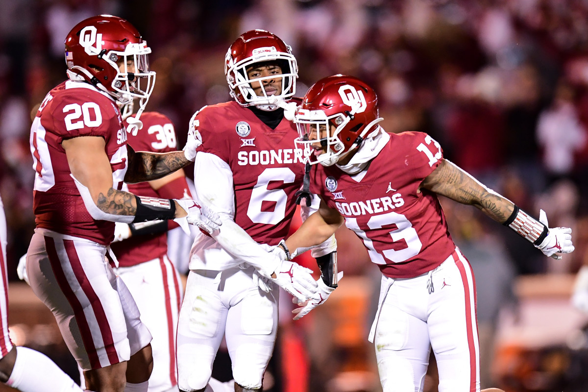 Tre Norwood (13) celebrates an interception with Robert Barnes (20) and Tre Brown (6).